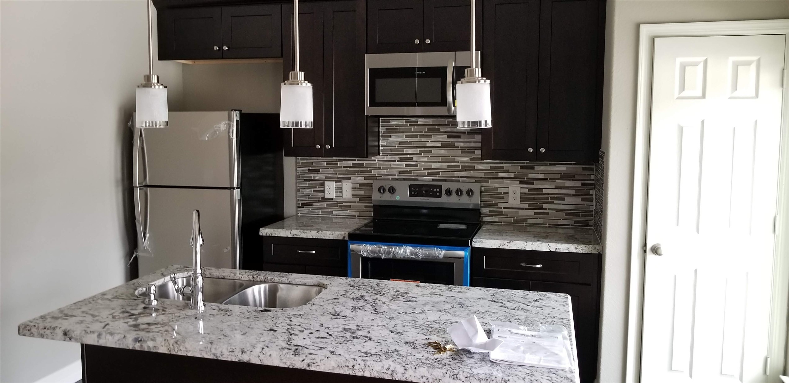 4204 Stassen Street, Unit B Houston, TX 77051 - Photo 5 of 11 a kitchen with kitchen island granite countertop a refrigerator and a sink