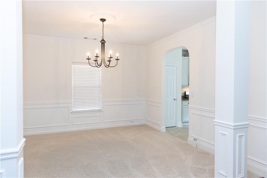 502 Streamside Place Canton, GA 30115 - Photo 6 of 33 an empty room with chandelier and windows