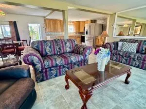 a living room with furniture a flat screen tv and a window