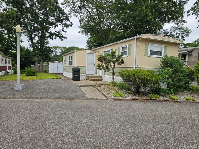 a view of a house with a yard and large trees