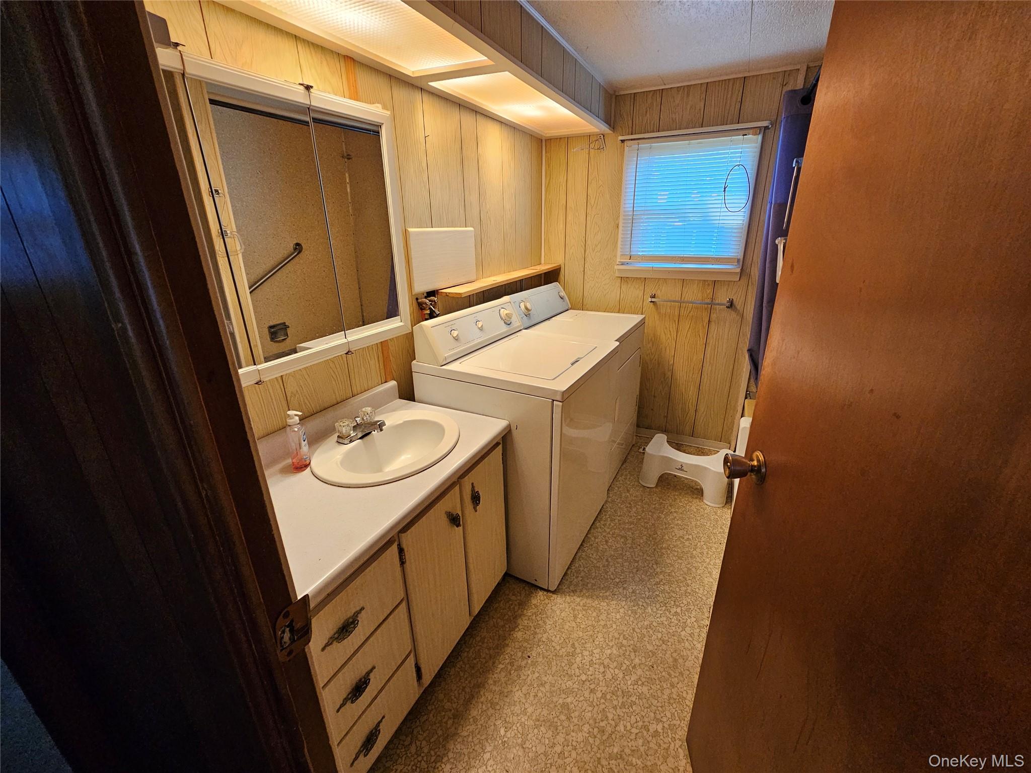 1964 River Road, Unit 37 Calverton, NY 11933 - Photo 12 of 13 a bathroom with a sink a washer and dryer