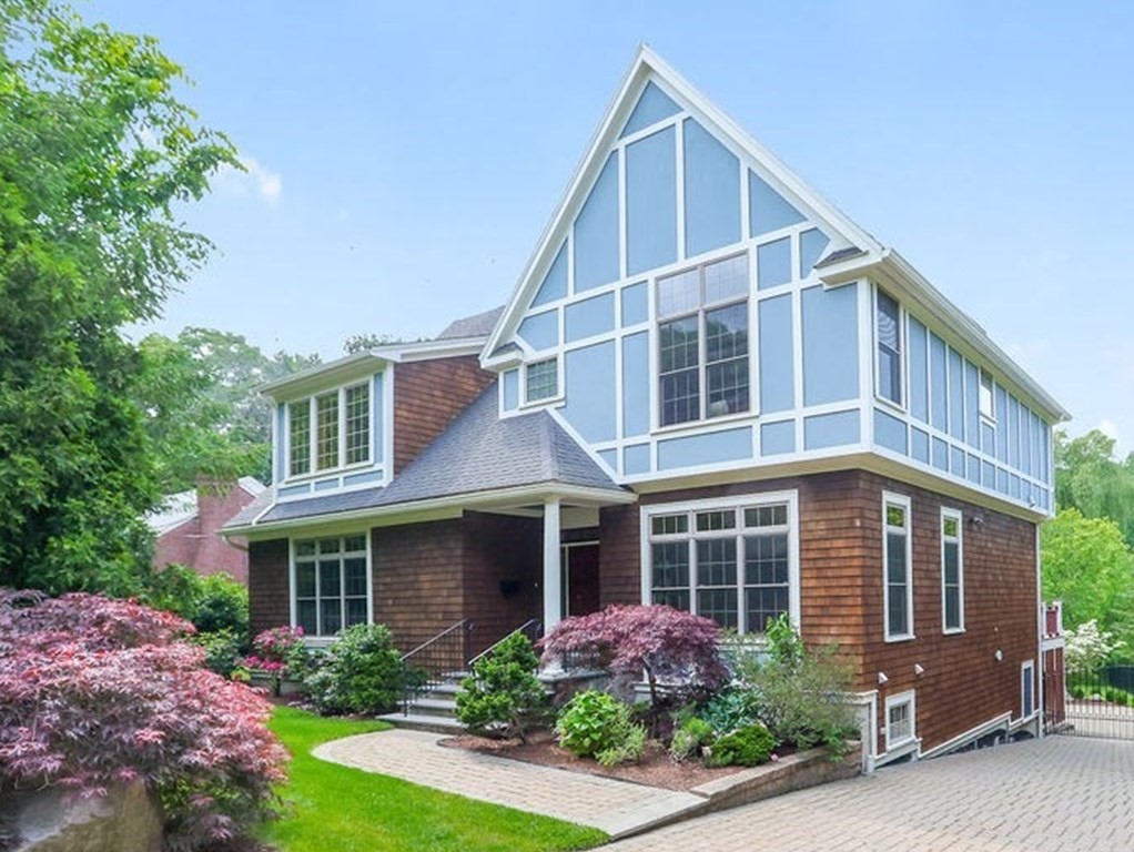 a front view of a house with a yard and potted plants