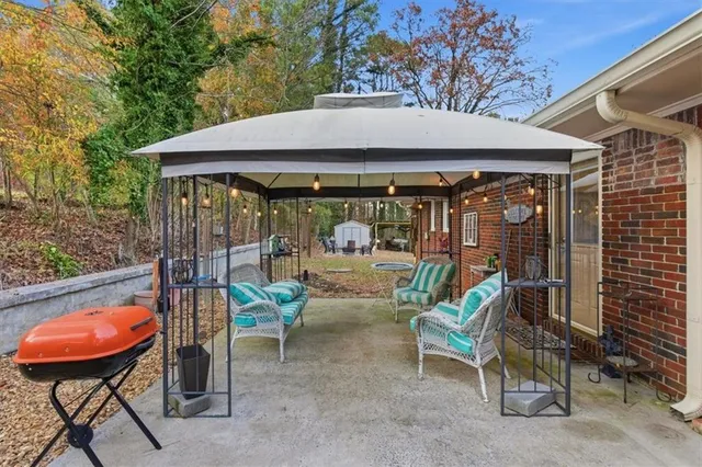 a view of a patio with a table and chairs under an umbrella