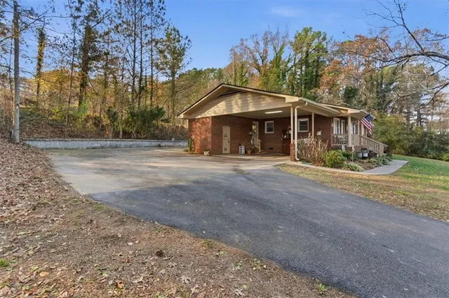 a view of a house with a yard and large trees