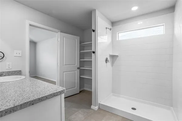 a bathroom with a granite countertop sink and shower