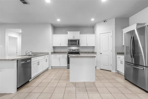 a kitchen with white cabinets a sink and white appliances