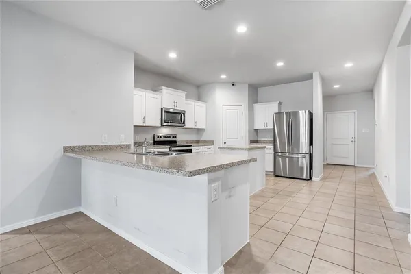 a kitchen with stainless steel appliances a refrigerator sink and microwave