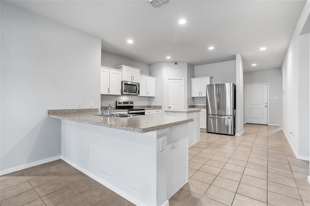 424 Amory Street Azle, TX 76020 - Photo 7 of 27 a kitchen with stainless steel appliances a refrigerator sink and microwave