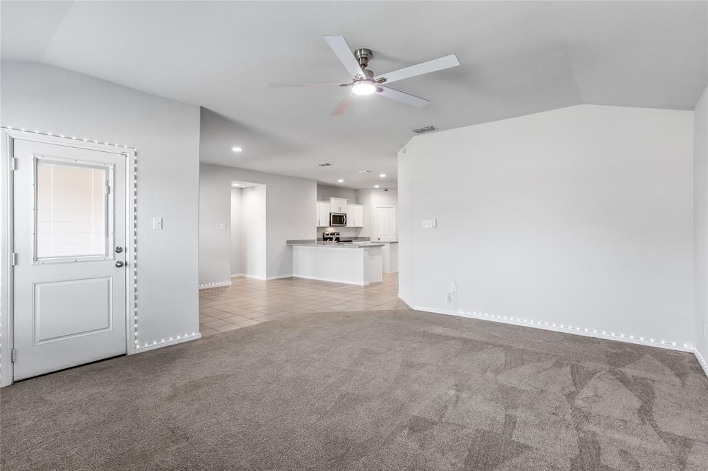 424 Amory Street Azle, TX 76020 - Photo 10 of 27 an empty room with a kitchen and a ceiling fan