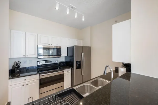 a kitchen with granite countertop a refrigerator and a sink