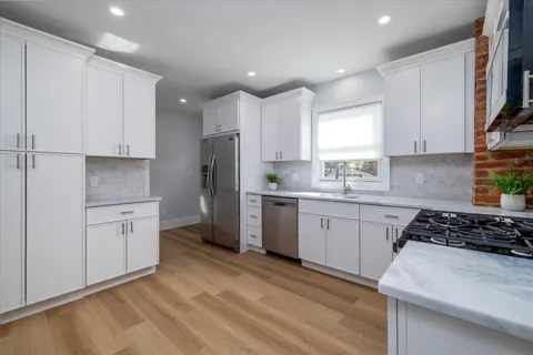 a kitchen with cabinets appliances a sink and a window