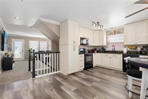 a kitchen with granite countertop a refrigerator stove top oven and sink
