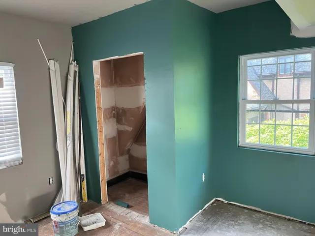 a view of a hallway with wooden floor and a dining room
