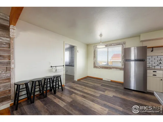 a kitchen with stainless steel appliances refrigerator wooden floor dining table and chairs