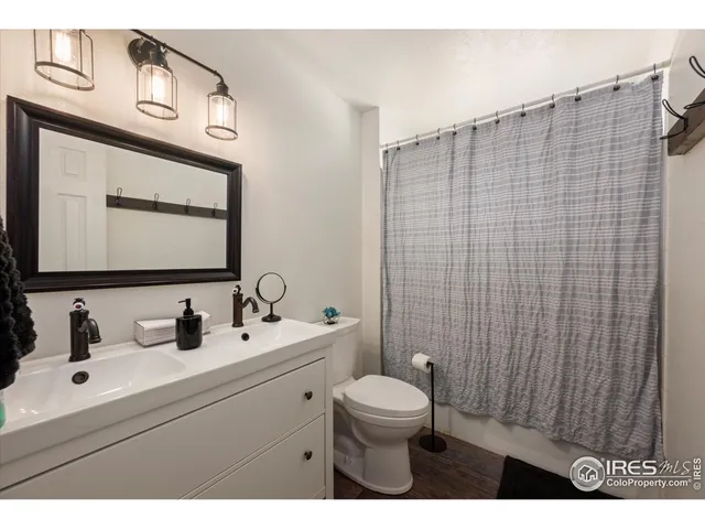 a bathroom with a toilet sink vanity and mirror