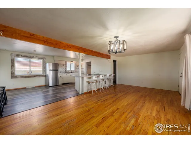 a view of a room with wooden floor and chandelier