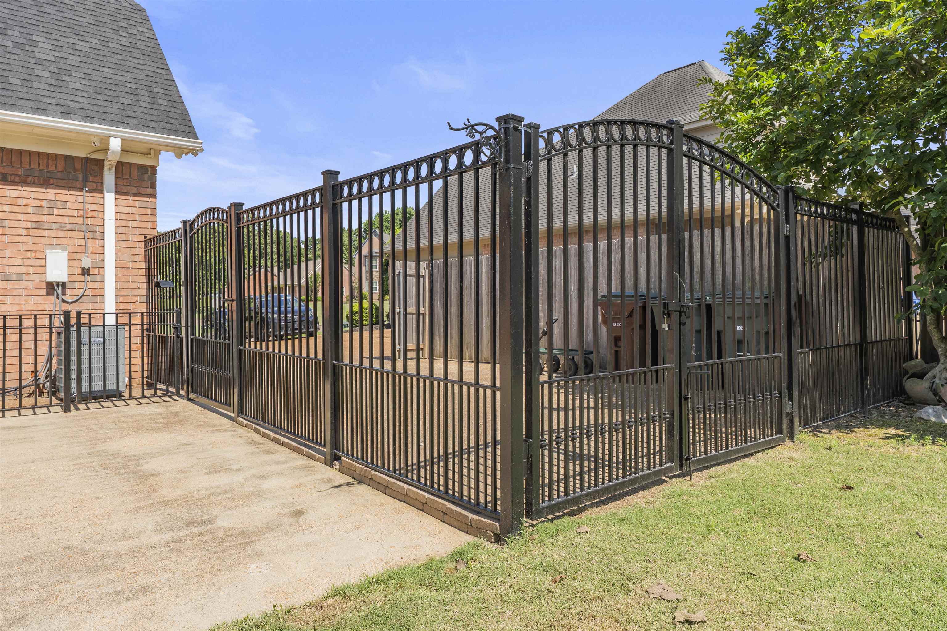 4279 High Plains Road Bartlett, TN 38135 - Photo 31 of 37 Custom black wrought iron fencing with an arched gate, brick perimeter, and a concrete patio space