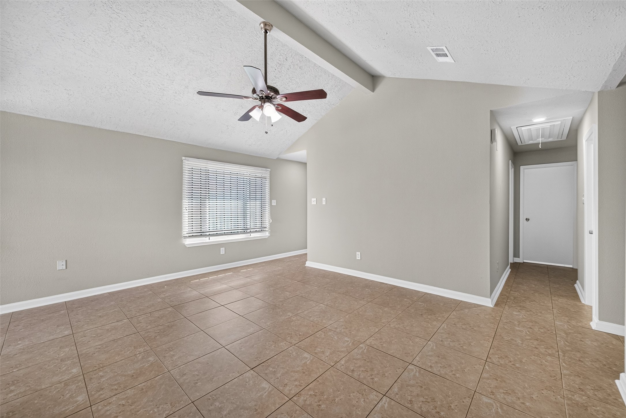 16203 Beck Ridge Drive Houston, TX 77053 - Photo 8 of 29 Living area featuring neutral tones, tile flooring, and a ceiling fan, enhanced by natural light from a large window.