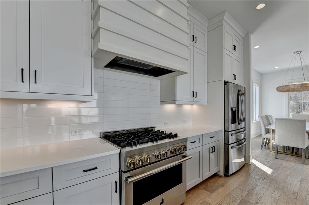 6785 Halcyon Way Alpharetta, GA 30005 - Photo 32 of 90 a kitchen with stainless steel appliances a stove a refrigerator and cabinets
