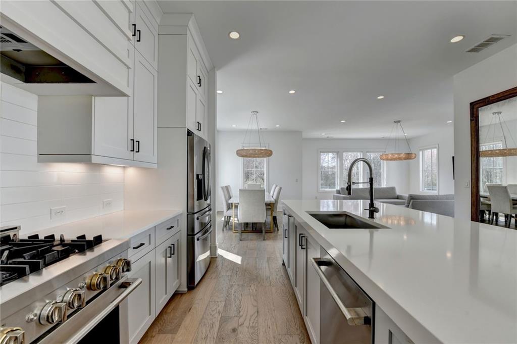 6785 Halcyon Way Alpharetta, GA 30005 - Photo 37 of 90 a kitchen with stainless steel appliances a sink a stove and a wooden floors