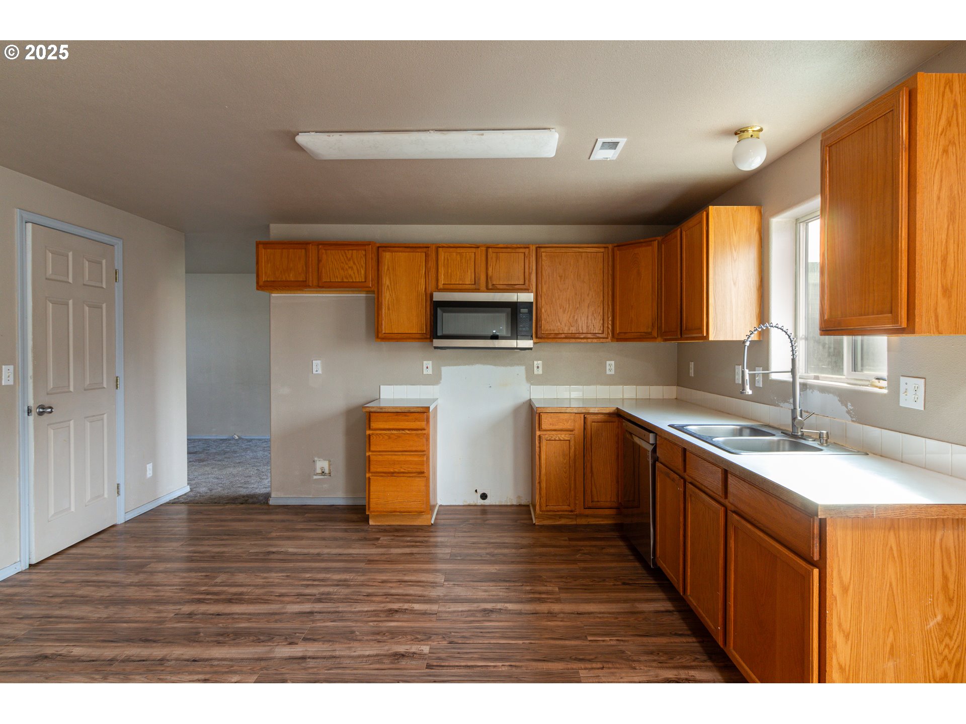 2464 Blue Jay Way Umatilla, OR 97882 - Photo 32 of 39 a kitchen with a sink cabinets and wooden floor