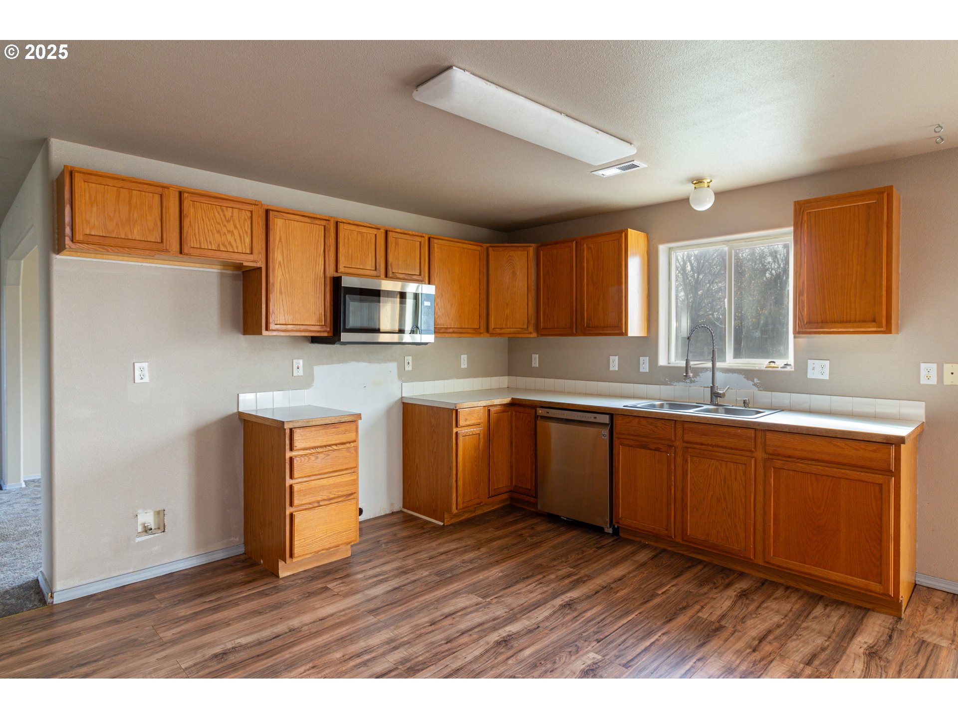 2464 Blue Jay Way Umatilla, OR 97882 - Photo 34 of 39 a kitchen with stainless steel appliances granite countertop a sink dishwasher stove and microwave with wooden cabinets