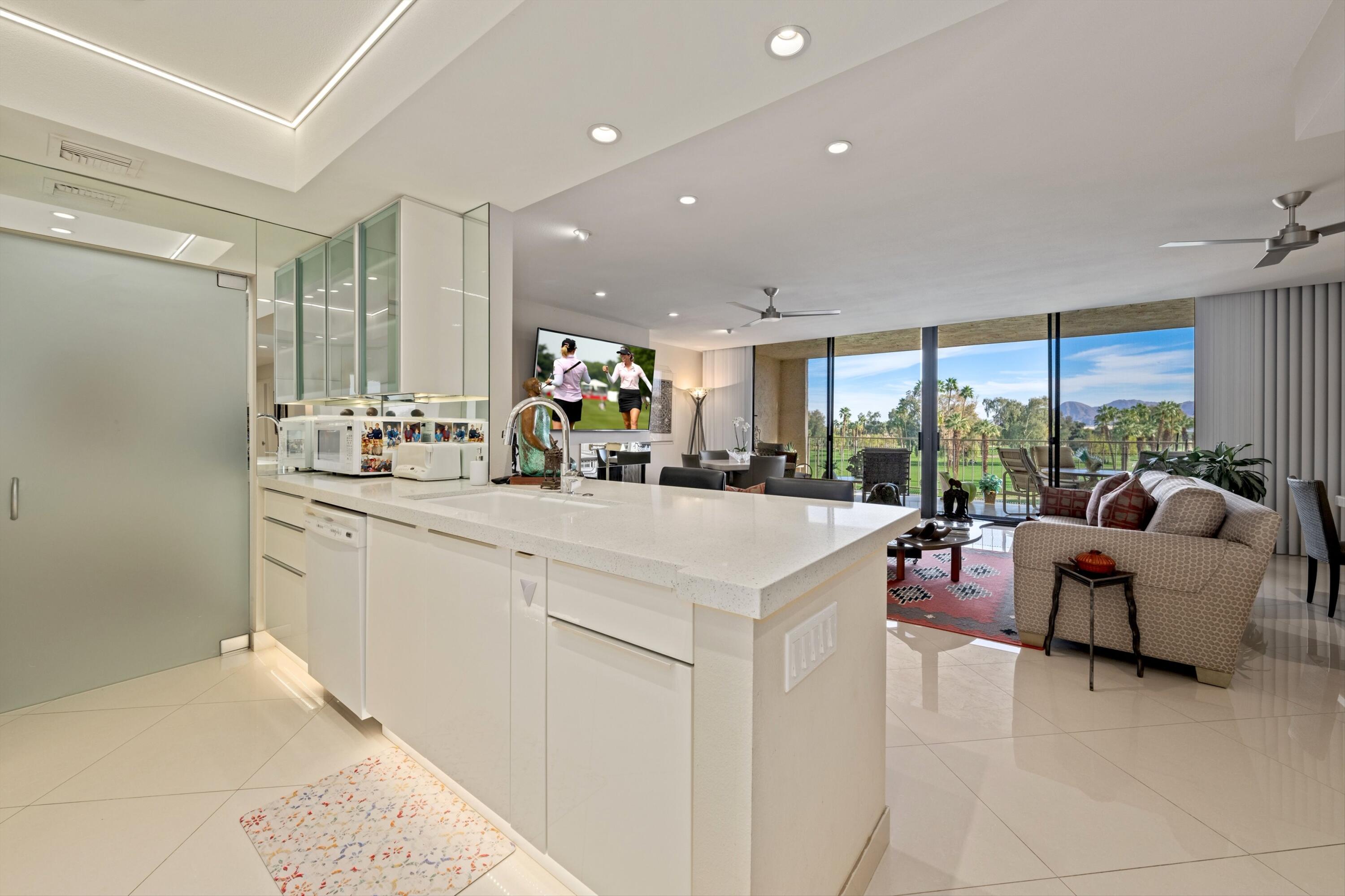 910 Island Drive, Unit 405 Rancho Mirage, CA 92270 - Photo 14 of 33 a kitchen with counter top space and living room view