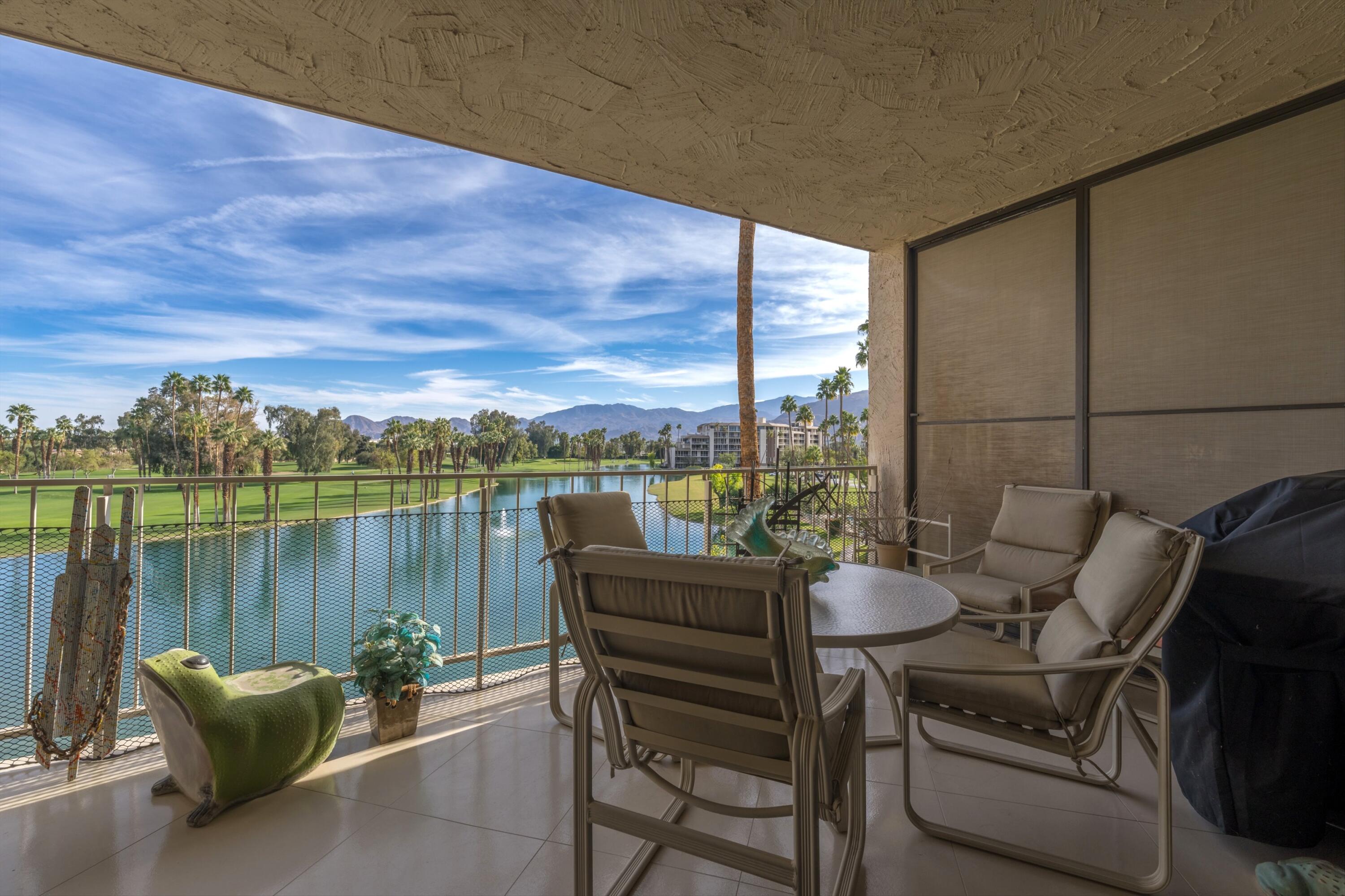 910 Island Drive, Unit 405 Rancho Mirage, CA 92270 - Photo 2 of 33 a balcony with furniture and a lake view