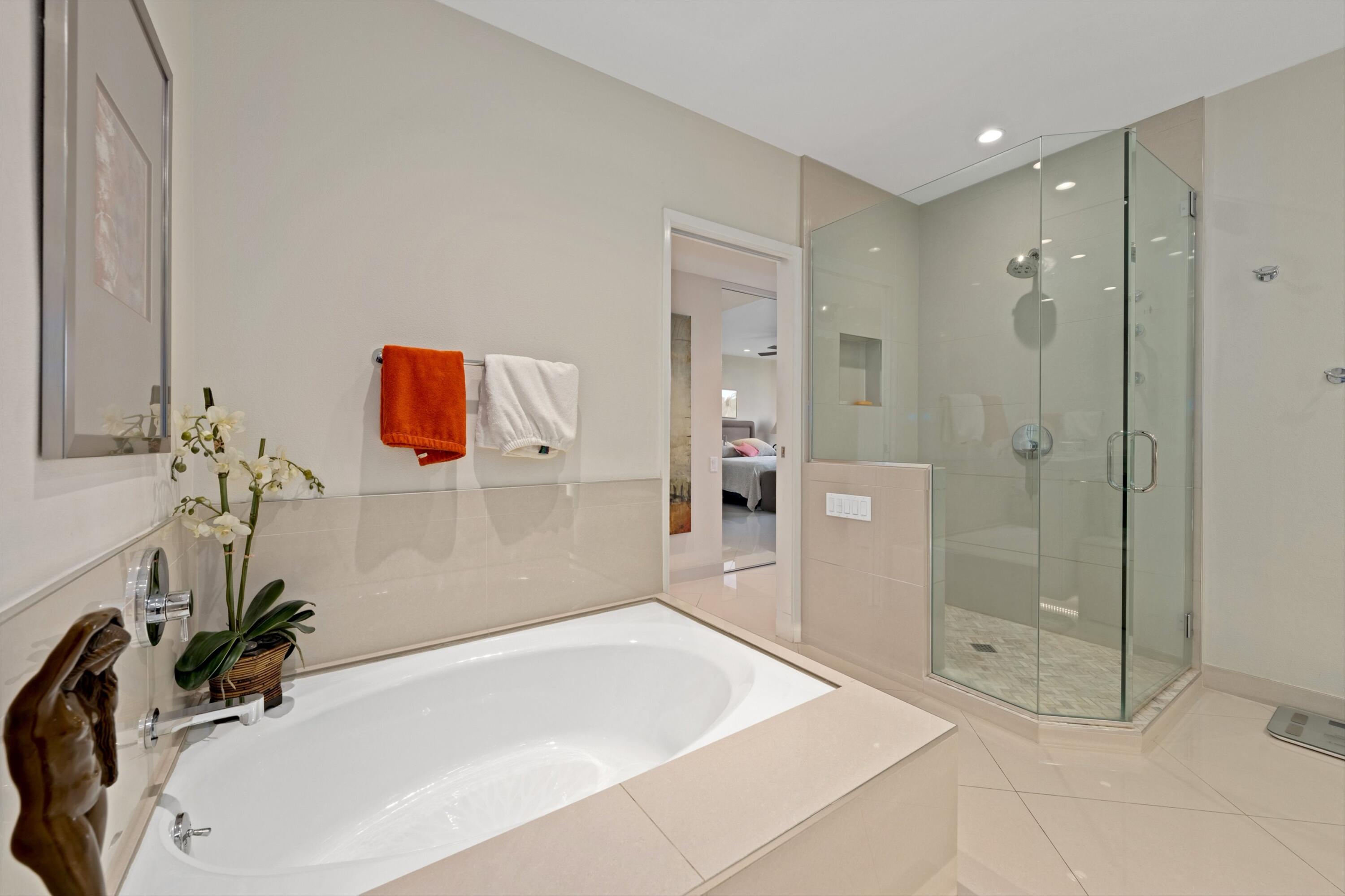 910 Island Drive, Unit 405 Rancho Mirage, CA 92270 - Photo 23 of 33 a bathroom with a tub shower sink and mirror
