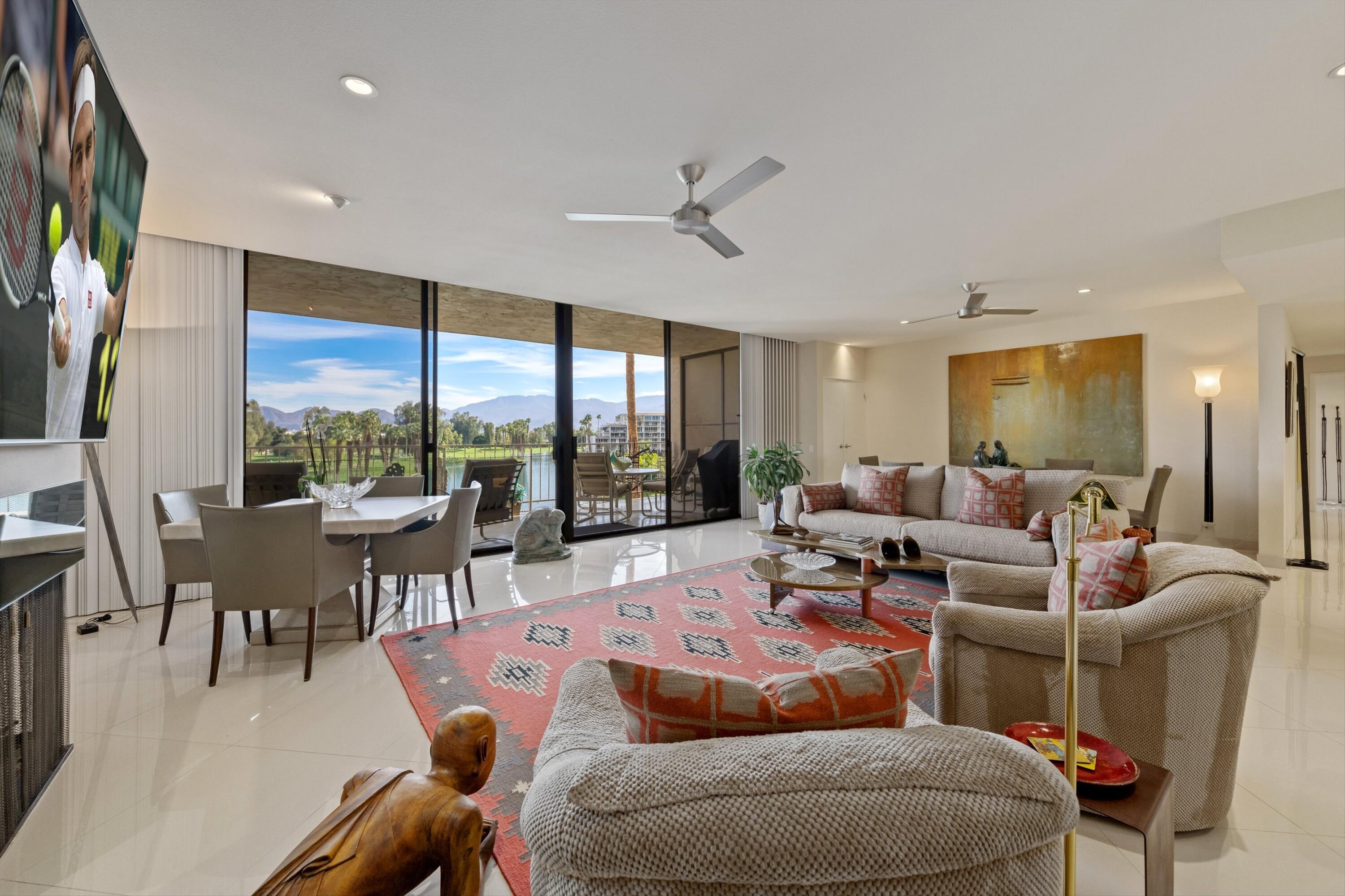 910 Island Drive, Unit 405 Rancho Mirage, CA 92270 - Photo 5 of 33 a living room with furniture ceiling fan and a large window