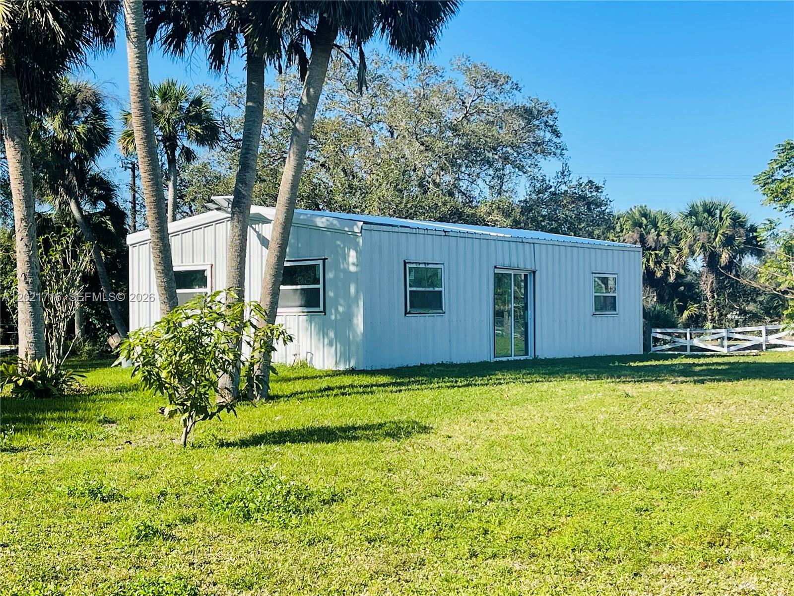 1326 Red Barn Rd N West Moore Haven, FL 33471 - Photo 2 of 13 a backyard of a house with potted plants and large tree