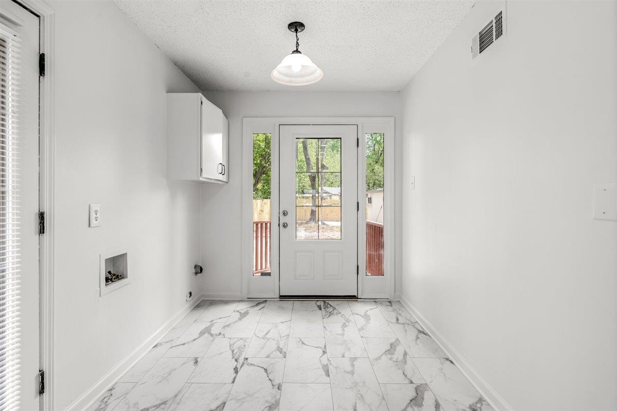 1244 Wells Station Road Memphis, TN 38122 - Photo 14 of 36 Doorway featuring marble look tiles and a textured ceiling