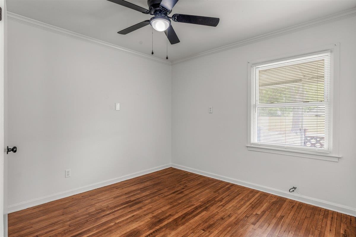 1244 Wells Station Road Memphis, TN 38122 - Photo 27 of 36 Empty room featuring crown molding, dark wood-style flooring, and ceiling fan