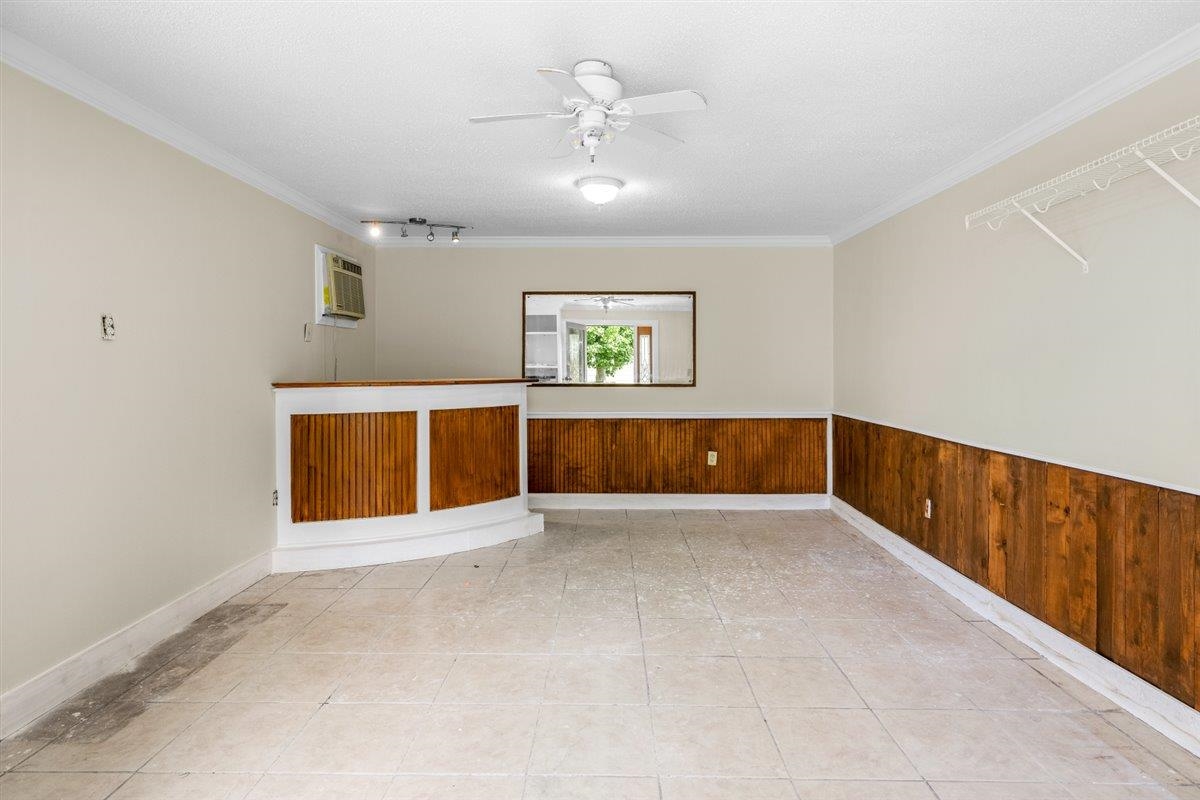 1244 Wells Station Road Memphis, TN 38122 - Photo 33 of 36 Unfurnished room with wooden walls, ceiling fan, a textured ceiling, light tile patterned floors, and ornamental molding