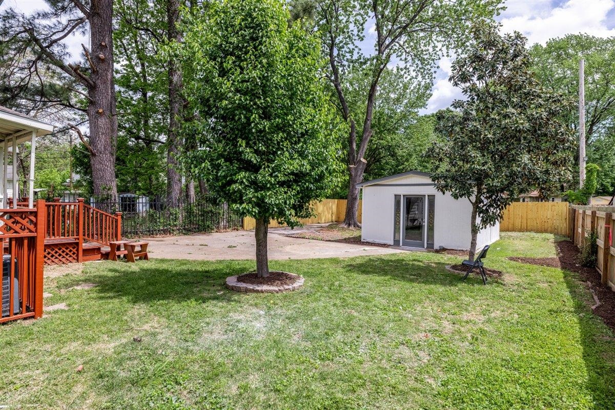 1244 Wells Station Road Memphis, TN 38122 - Photo 5 of 36 Fenced backyard with a wooden deck, a storage shed, and a patio