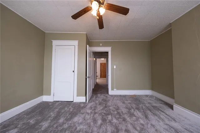 a view of empty room with window and ceiling fan