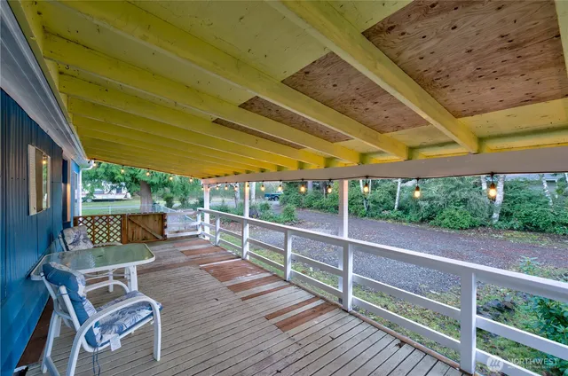 a view of a patio with table and chairs potted plants with wooden floor and fence