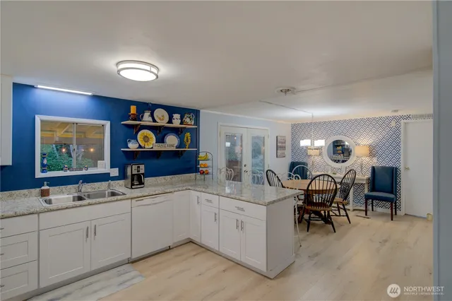 a kitchen with stainless steel appliances kitchen island a table chairs and a refrigerator