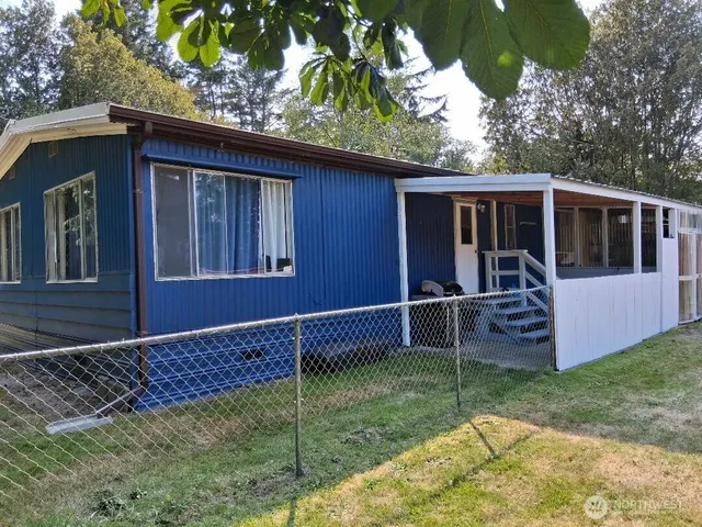 a view of a house with a backyard porch and wooden floor