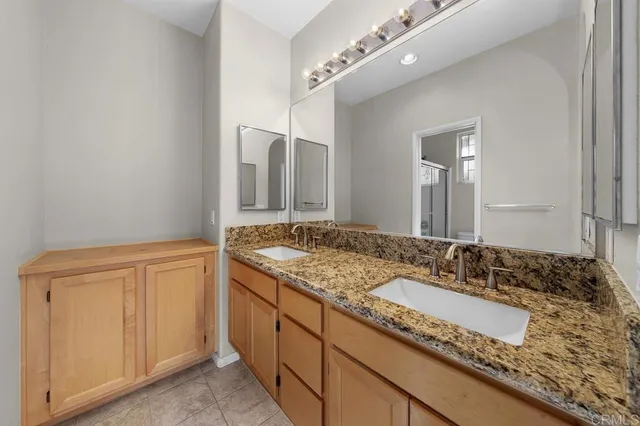 a bathroom with a granite countertop sink and a mirror