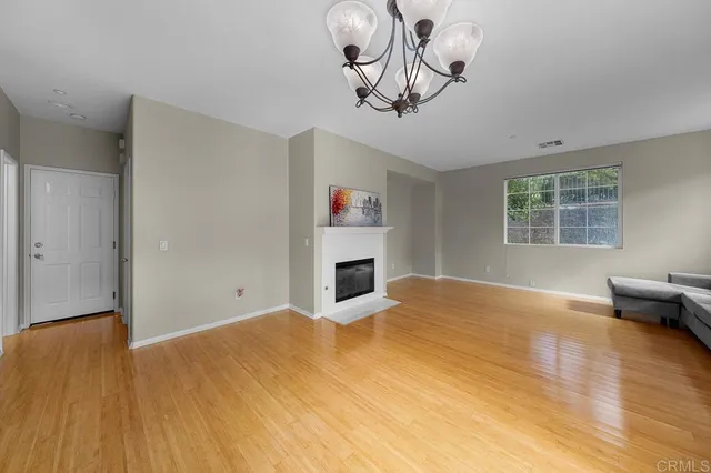 a view of empty room with wooden floor and window