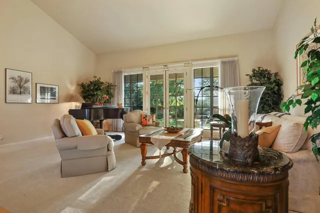 a view of a dining room with furniture a chandelier and window