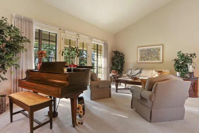 a living room with furniture a fireplace and a dining table with wooden floor