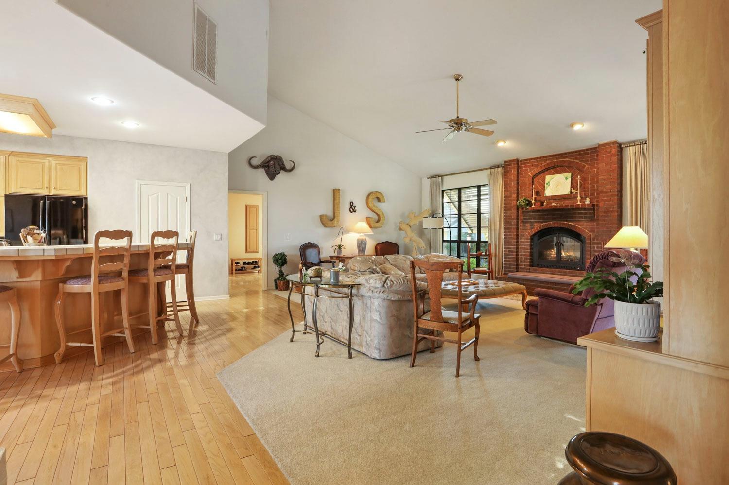11791 Alpine Road Lodi, CA 95240 - Photo 18 of 74 a living room with furniture a fireplace and a dining table with wooden floor