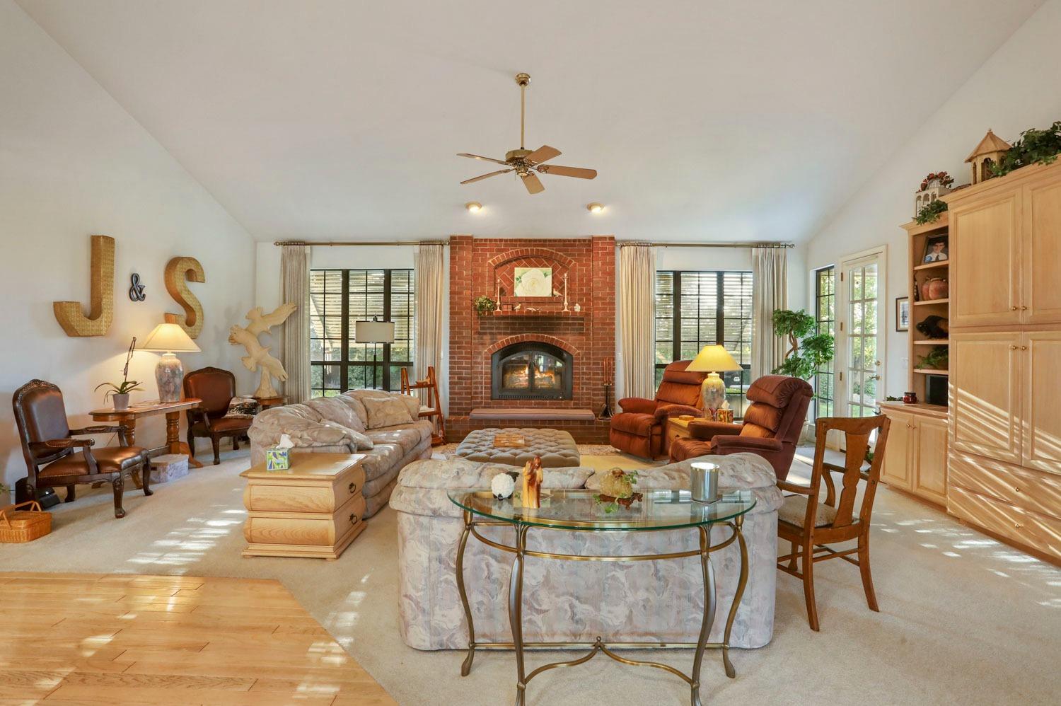 11791 Alpine Road Lodi, CA 95240 - Photo 20 of 74 a living room with furniture a fireplace and a chandelier