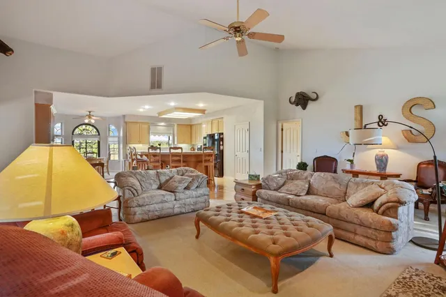 a kitchen with stainless steel appliances granite countertop a stove a refrigerator a kitchen island a stove and white cabinets