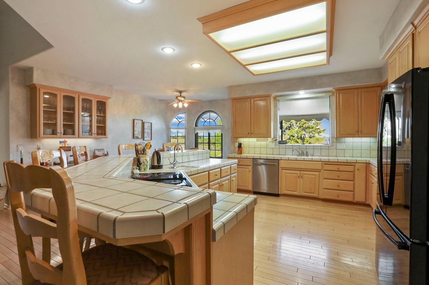 11791 Alpine Road Lodi, CA 95240 - Photo 27 of 74 a kitchen with stainless steel appliances granite countertop a stove a refrigerator a kitchen island a stove and white cabinets