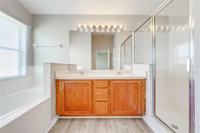 a bathroom with a tub a sink and a large mirror