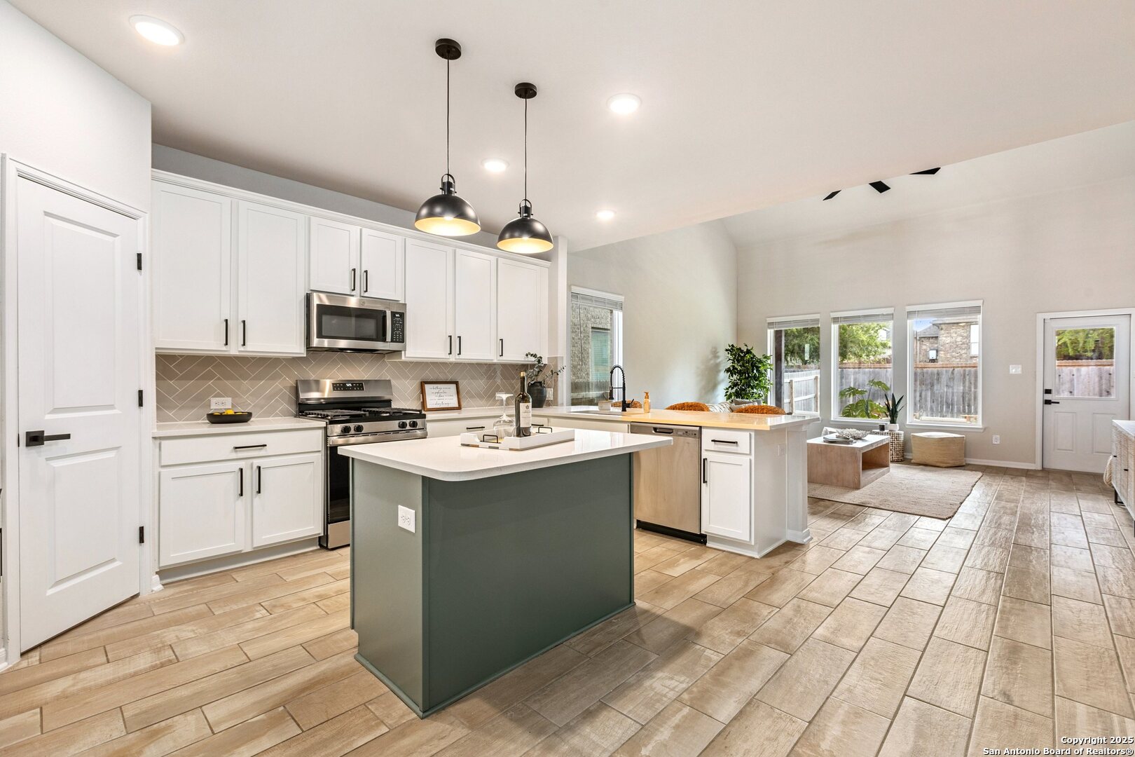 1707 Lawnside Road San Antonio, TX 78245 - Photo 21 of 64 a kitchen with kitchen island granite countertop a sink appliances cabinets and a counter top space