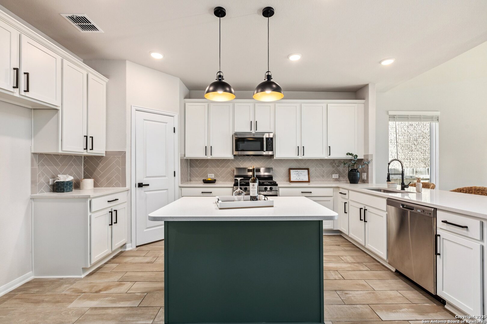 1707 Lawnside Road San Antonio, TX 78245 - Photo 22 of 64 a kitchen with cabinets a sink and appliances